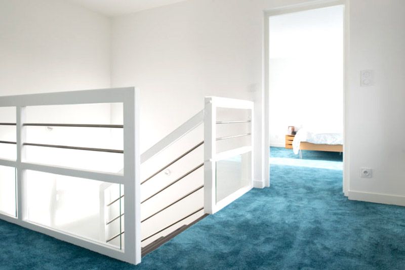 Mezzanine avec escalier blanc et moquette bleue